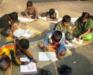 Photo of children studying while sitting on the floor. 