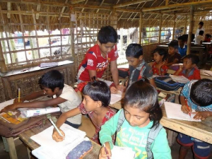 Photo of a child teaching younger children in a classroom. 